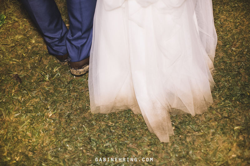 noivos no final da festa de um casamento em casa com a barra do vestido sujo